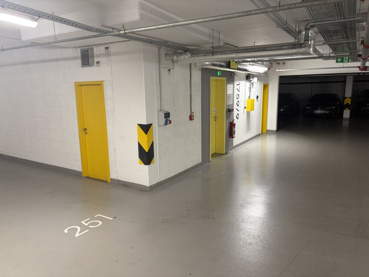 Pedestrian exit: with your back to the car, walk left to the yellow door marked 
